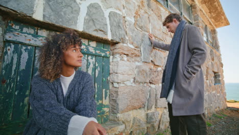 frustrated pair feeling sad at chateau near ocean. models posing abandoned place