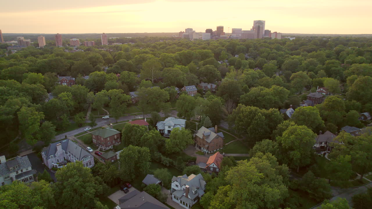 Pull back over beautiful nice homes in Clayton neighborhood with skyline on the horizon at sunset in St