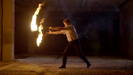 male artist performing fire show at dark in slow motion.