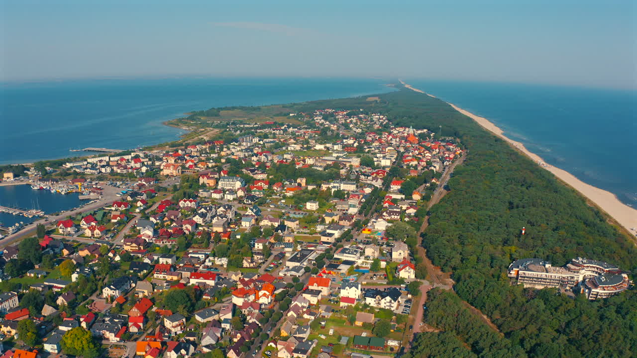폴란드의 야스타니아 시 위를 날아다니는 드론, 은 여름 날, 배경에는 발트해