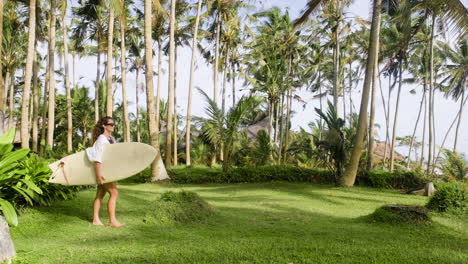 Woman-walking-and-holding-surfboard