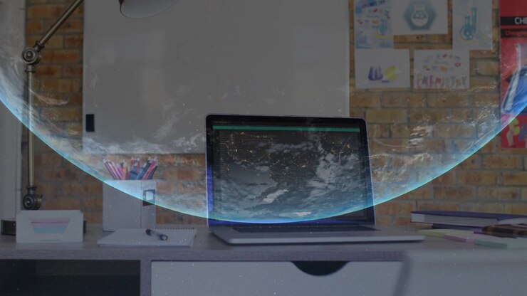 Closed laptop on desk, blue arc appearing and rising into planetary globe overlay for technology