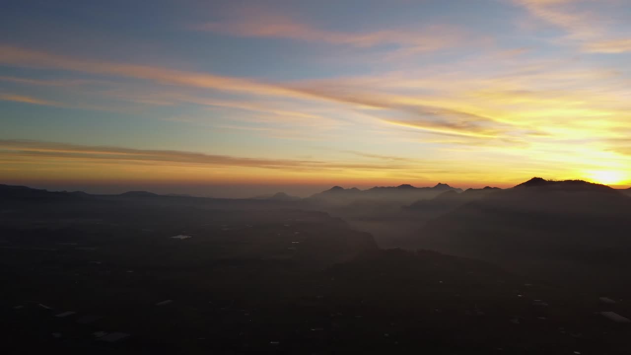 Summer landscape panoramic image of rural fields in mountains under cloudy sky in evening light at Amanecer Quexnol. Majestic autumn scenery of foggy valley mountain range at early morning sunrise.