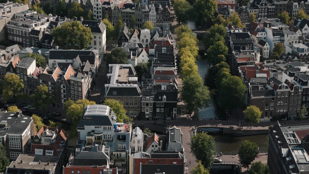 Aerial dolly right along Amsterdam canal with iconic houses and street life