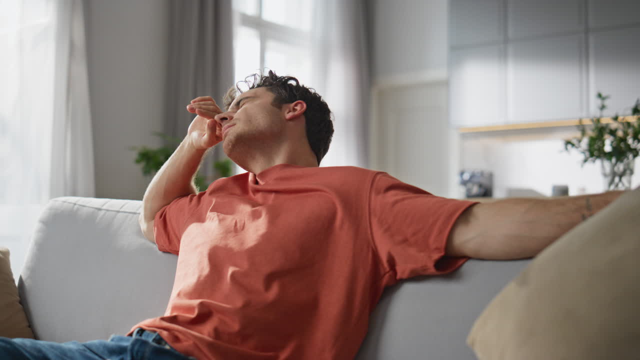 Tired man falling coach feeling exhausted closeup. Freelancer opening laptop