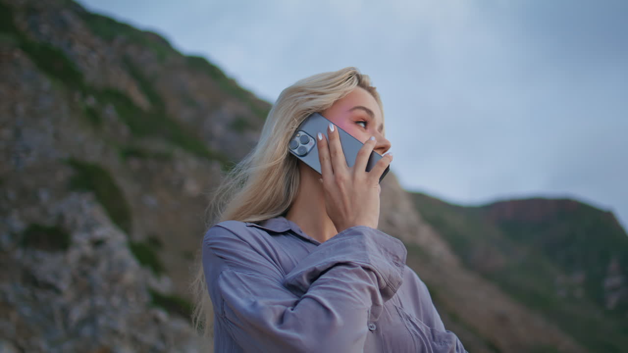 밖에서 스마트폰으로 대화를 나누는 소녀. 웃는 편안한 여성