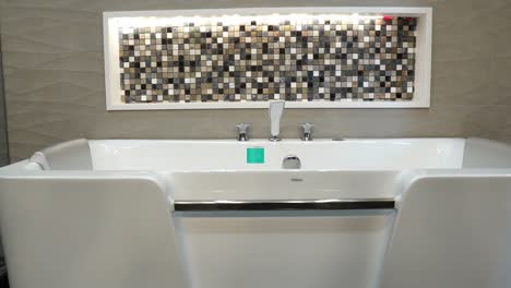 gran bañera blanca y moderna con azulejos de diseño en el fondo de la pared.