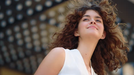 curly girl looking into distance outdoors. fashion model smiling outside.