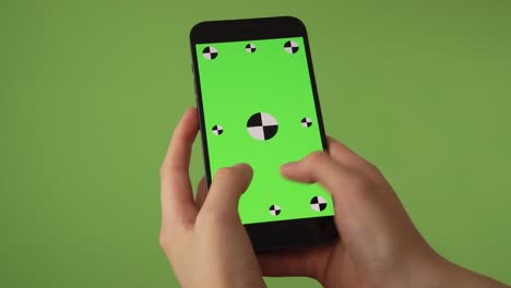 woman-typing-on-phone-in-front-of-green-screen