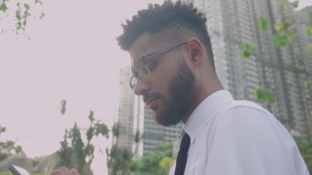 Businessman Scrolling on Smartphone Outdoors