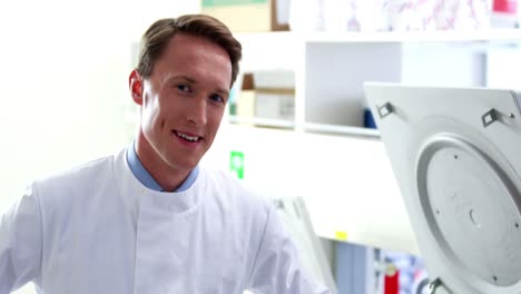 happy scientist leaning against centrifuge