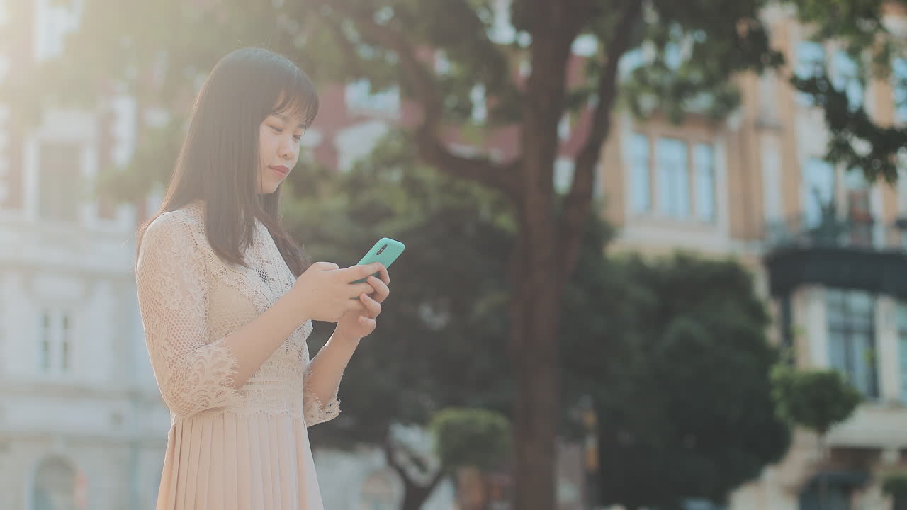 도시 환경에서 스마트폰을 사용하는 여성