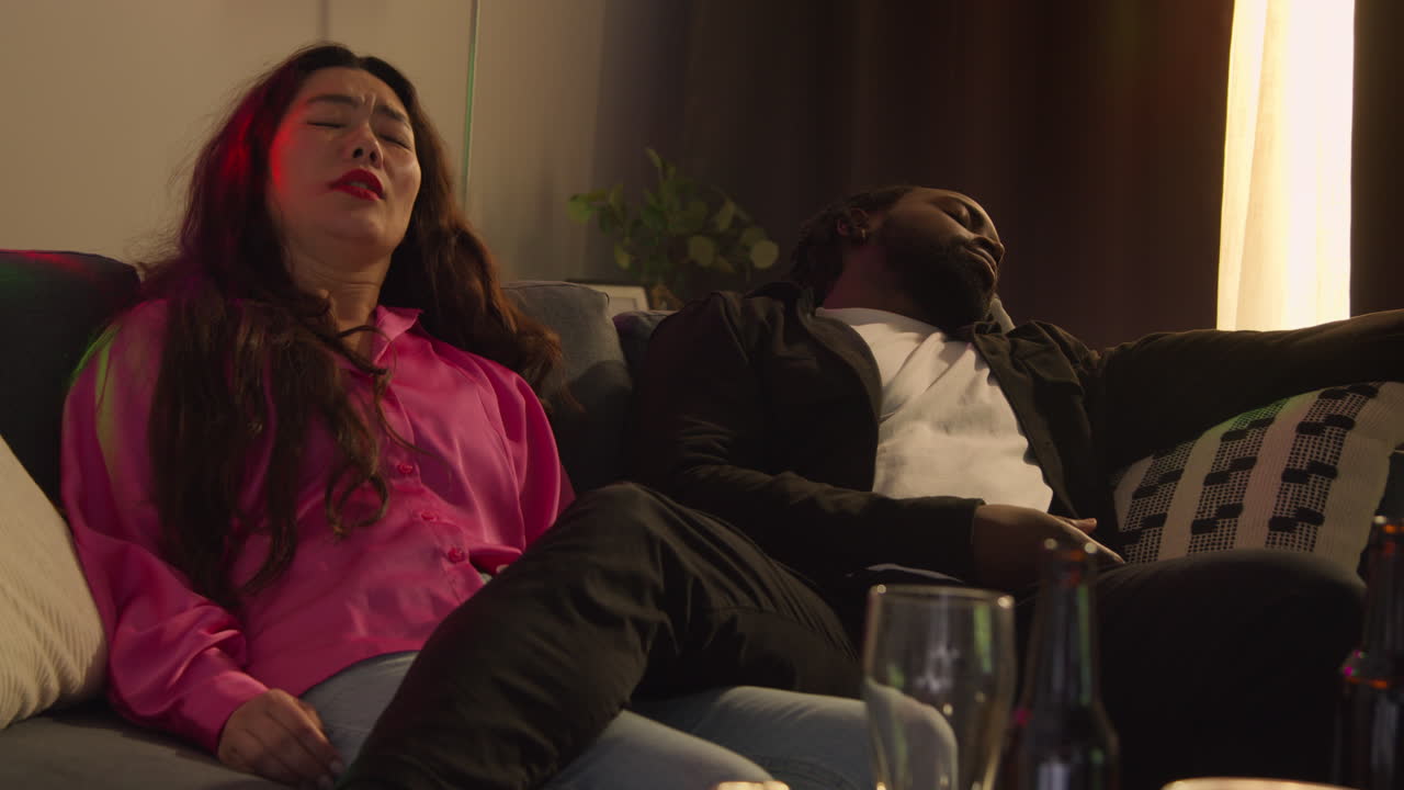 pareja despertando en el sofá después de beber alcohol en la fiesta de la casa sufriendo de resaca