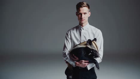 man holding small animal in studio