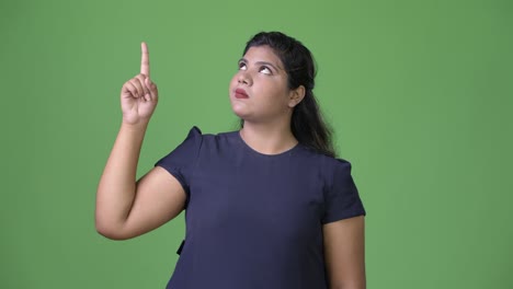 joven sobrepeso hermosa mujer de negocios india contra fondo verde