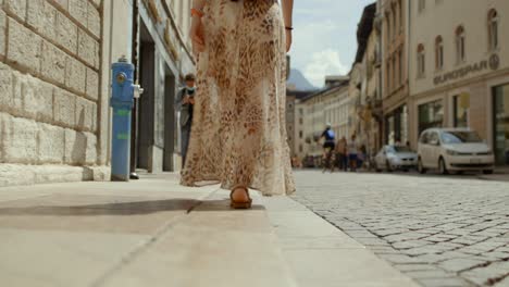 Low-Angle-Aufnahme-Einer-Alleinreisenden-Im-Sommerkleid,-Die-An-Einem-Sonnigen-Tag-Die-Europäische-Straße-Entlang-Spaziert