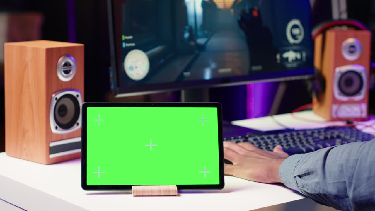 Mockup bærbar computer på skrivebord ved siden af mand, der spiller SF videospil