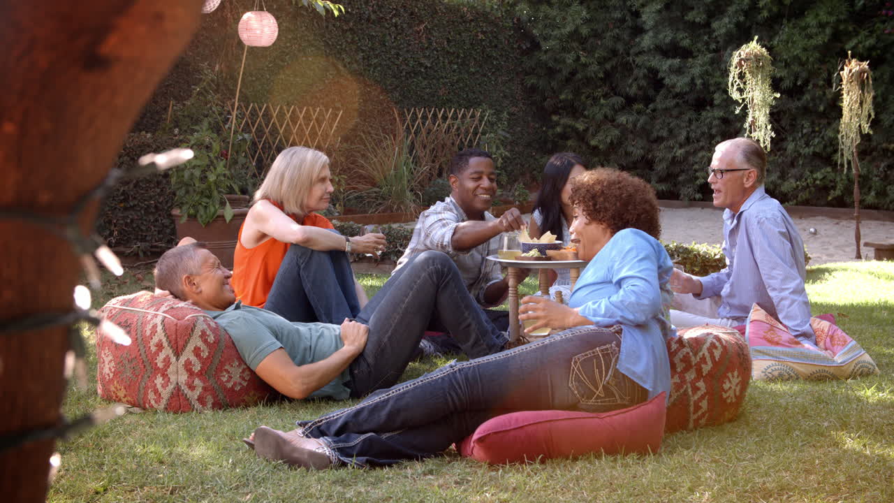 뒷마당 에서 함께 피크닉 을 즐기는 성숙 한 친구 들 의 그룹