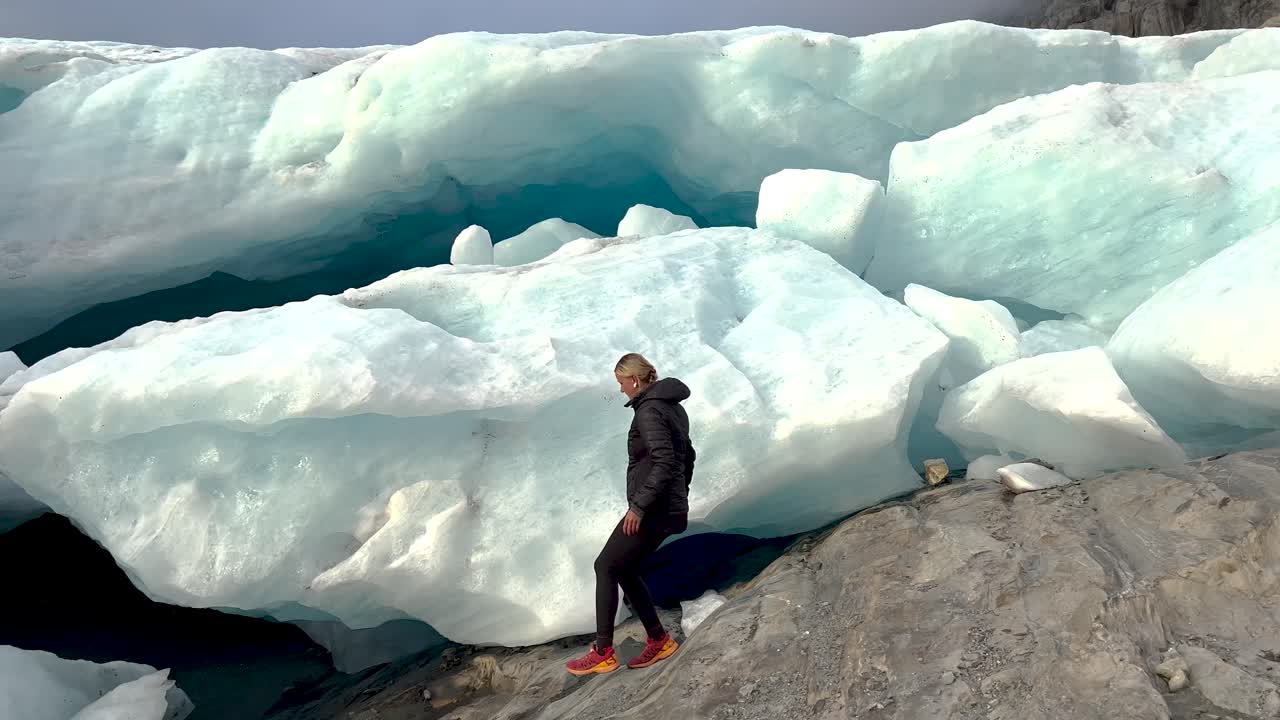 Kvinde udforsker isgrotte i Brewster Glacier, alpint landskab i New Zealand. Vandring i naturen
