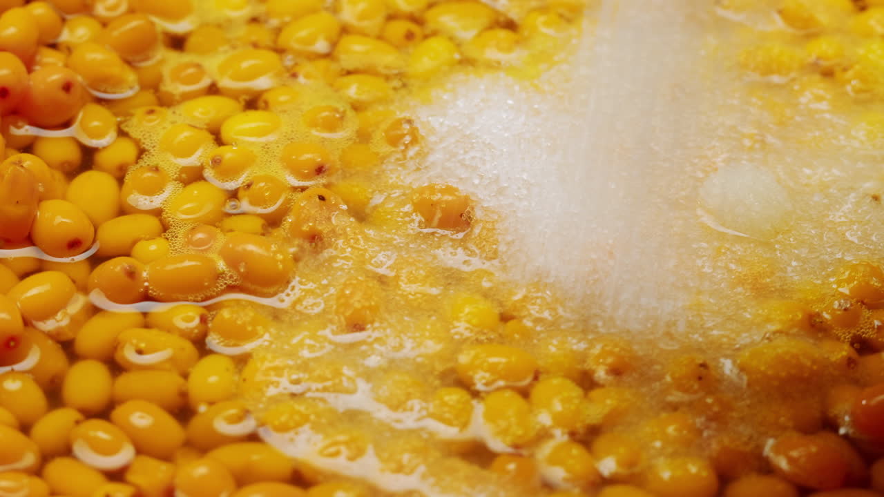 bayas saludables de espino marino para beber té, bayas maduras congeladas en frasco de vidrio y ramas con hojas vista superior en fondo rústico de madera oscura, genial para la piel, el corazón, los vasos y el sistema inmunológico.