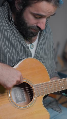 bearded man playing acoustic guitar