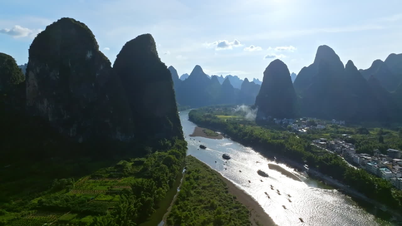 drones siguiendo barcos turísticos en el río li en medio de las montañas cársticas en china
