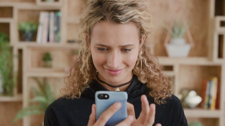 ritratto di una giovane studentessa bionda che utilizza uno smartphone bella ragazza che invia messaggi di testo navigando online sui social media godendo della comunicazione mobile serie di persone reali