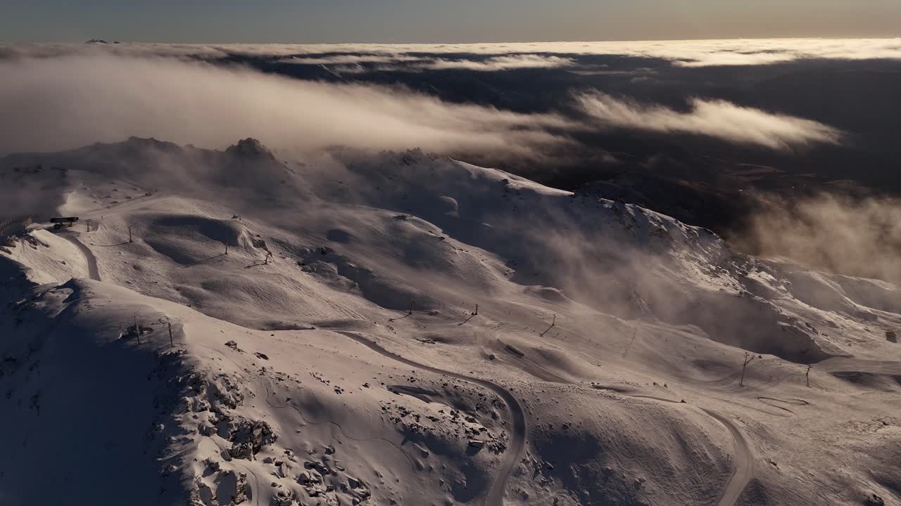 Filmato aereo con drone sulle cime e sui pendii innevati del monte Cardrona in Nuova Zelanda all'alba