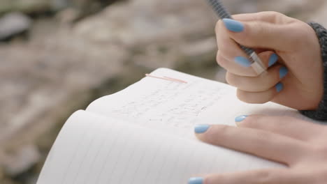 close up hands woman writing in diary journal teenage girl expressing lonely thoughts on seaside beach