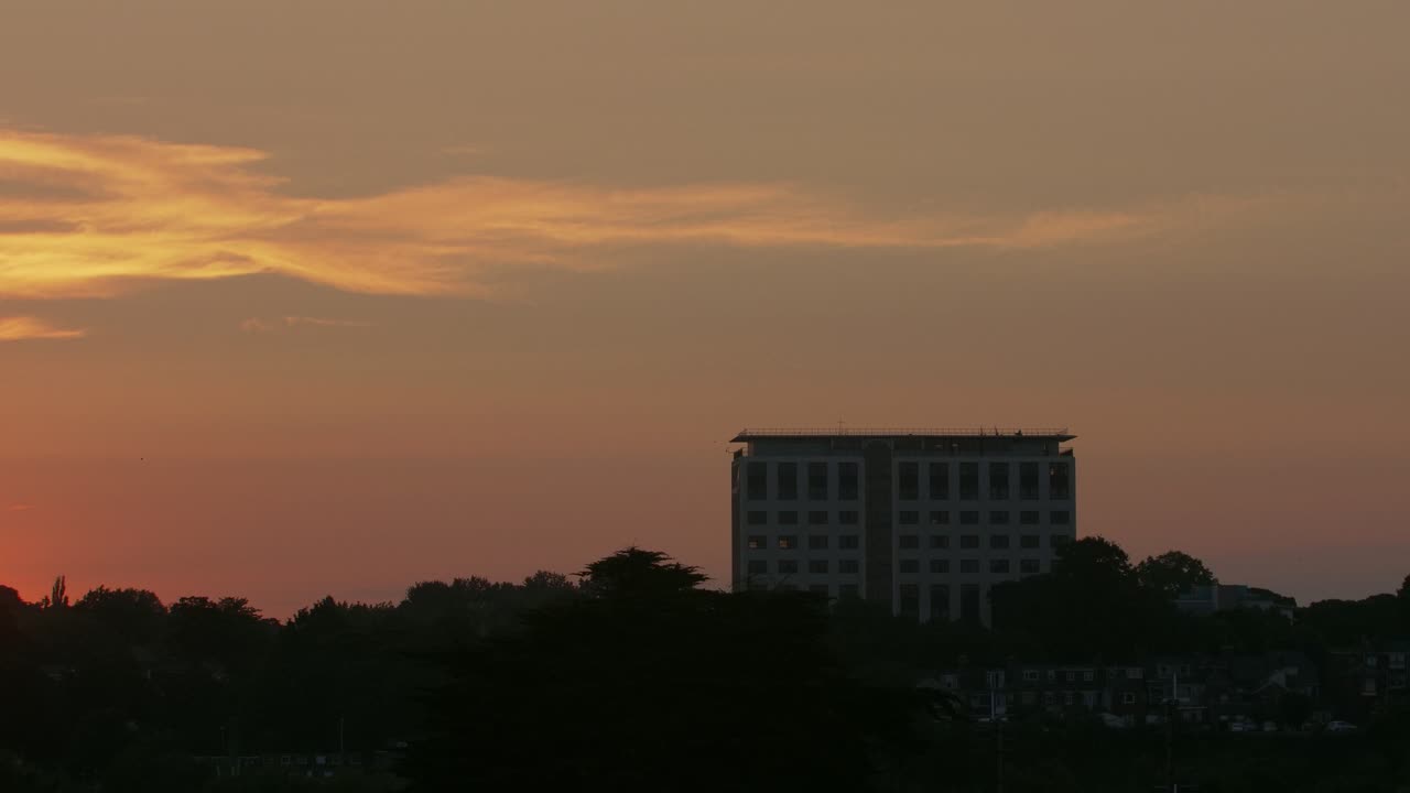 Building silhouetted against a colorful sky at sunset