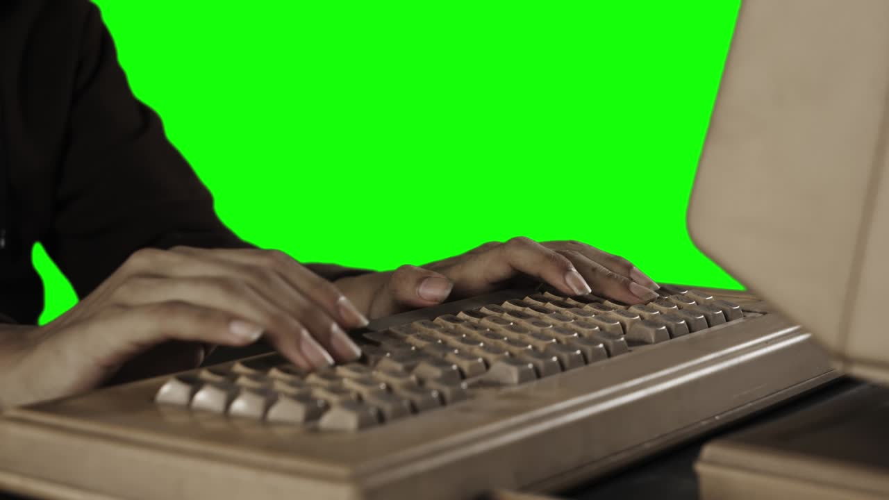 manos de un joven escribiendo en un teclado viejo