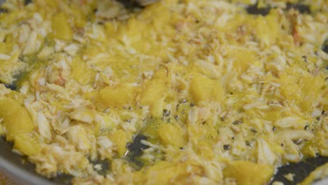 carne de cangrejo frita con pulpa de naranja en sartén caliente