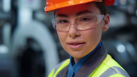 Closeup-engineer-looking-camera-wearing-safety-uniform-on-modern-facility.