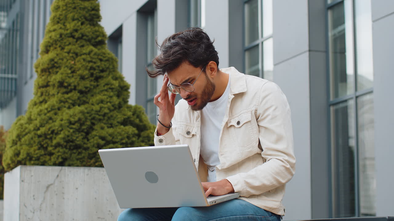 Displeased indian man use laptop surprised by bad news fortune loss game fail lottery results