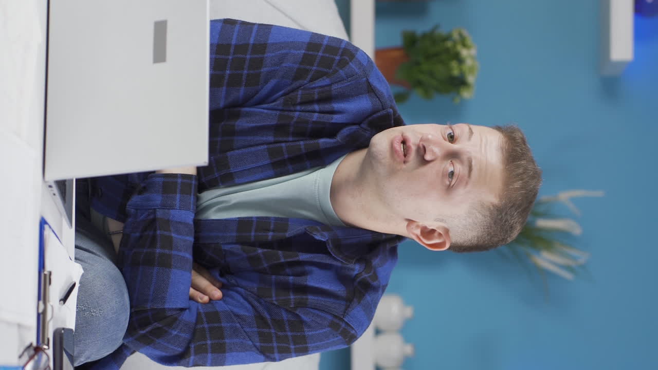 vídeo vertical del hombre que trabaja desde casa se enoja, se siente ofendido y triste.