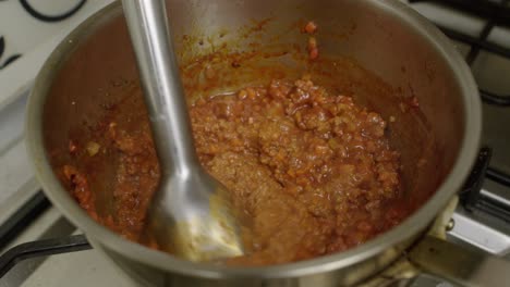 triturar los ingredientes de la carne con una batidora eléctrica en una olla de metal
