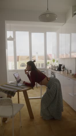 woman eating while video calling in a kitchen