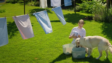 woman and dog drying laundry in garden