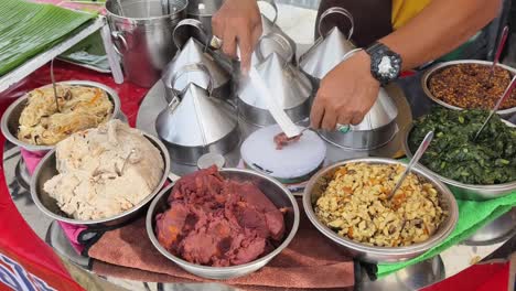 preparando albóndigas al vapor asiáticas en un puesto de comida callejera