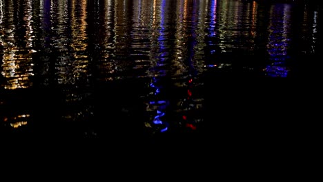 luces coloridas que se reflejan en el agua por la noche