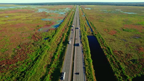 Luftaufnahme:-Autobahn-Mit-Angrenzender-LKW-Raststätte,-Umgeben-Von-Feuchtgebieten