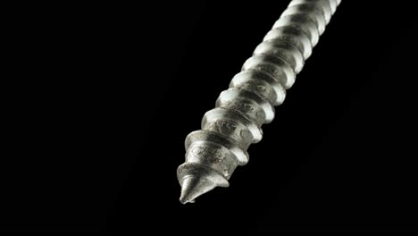 close-up of a metal screw on a black background