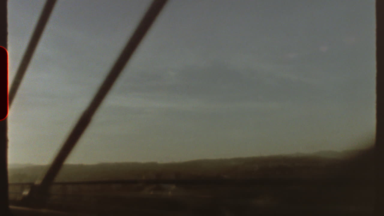 Filmed on super 8 film Vintage vibes emanate from this super 8 film aesthetic, showcasing a journey across a bridge with blurry landscapes in the background