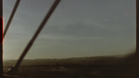 filmed on super 8 film vintage vibes emanate from this super 8 film aesthetic, showcasing a journey across a bridge with blurry landscapes in the background