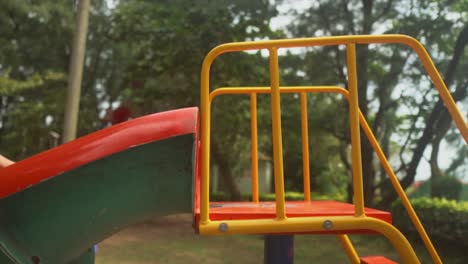 Kleine-Kinder-Spielen-Auf-Einer-Rutsche-Auf-Einem-Bunt-Bemalten-Spielplatz