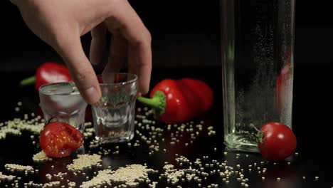 man takes a glass filled with vodka, drinks it and put empty glass back