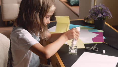 Blonde-Girl-Sitting-At-The-Desk-While-Working-With-Cardboard