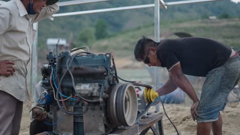 workers repairing a boat engine outdoors