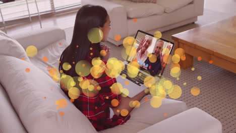 animación de puntos de luz brillantes sobre una feliz mujer caucásica en una videollamada portátil con su familia