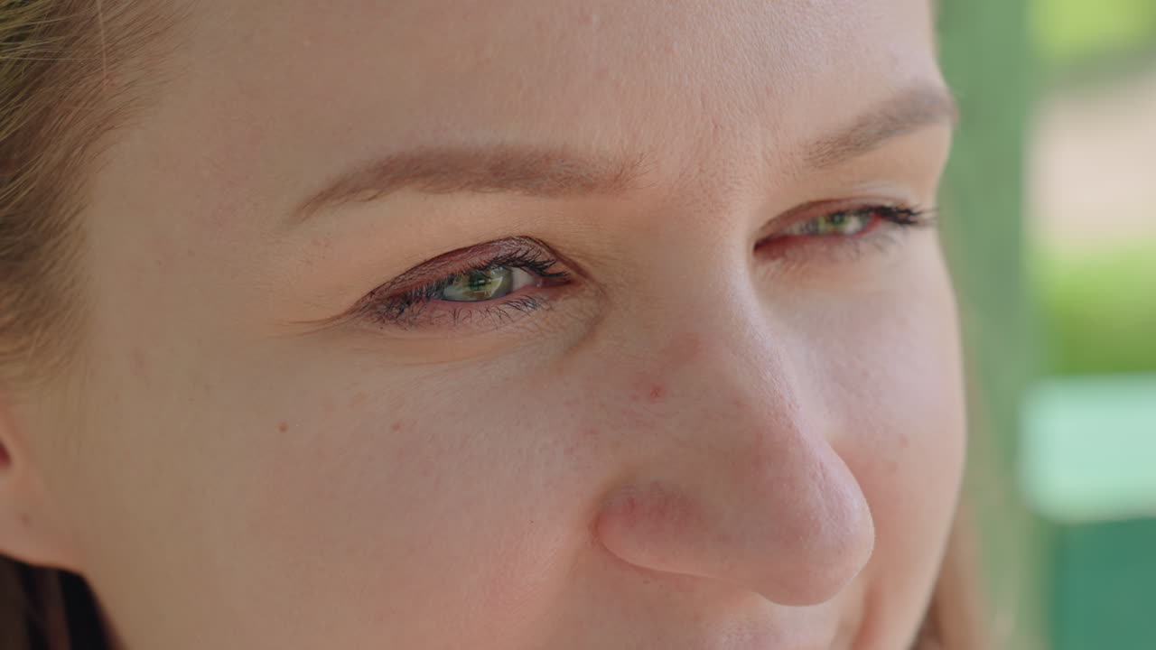 평화로운 백인 여성이 공원에서 휴식을 취하고 있어요. 푸르른 녹색 배경에서 부드러운 미소를 짓고 있는 평온한 여성, 햇볕이 잘 드는 공원에서 편안하게 앉아 사려 깊은 표정을 짓고 있는 편안한 백인 여성